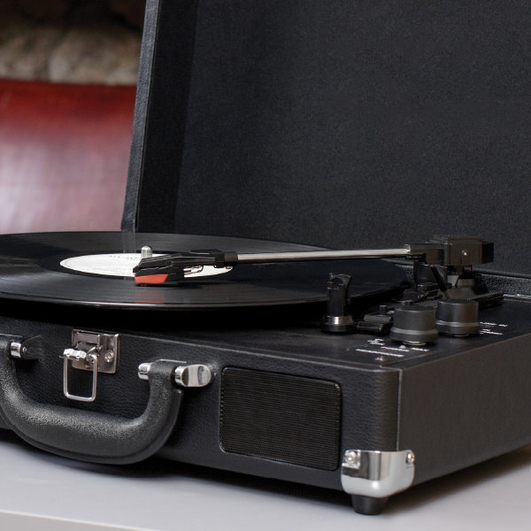 Black Auryvox Heritage VT-80 Portable Turntable on a gray surface with a record inside