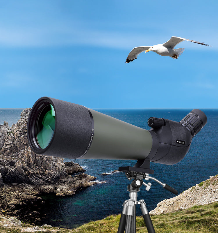 Bosco HD-7 Spotting Scope on a tripod with a scenic background of rocks and a bird flying over water.