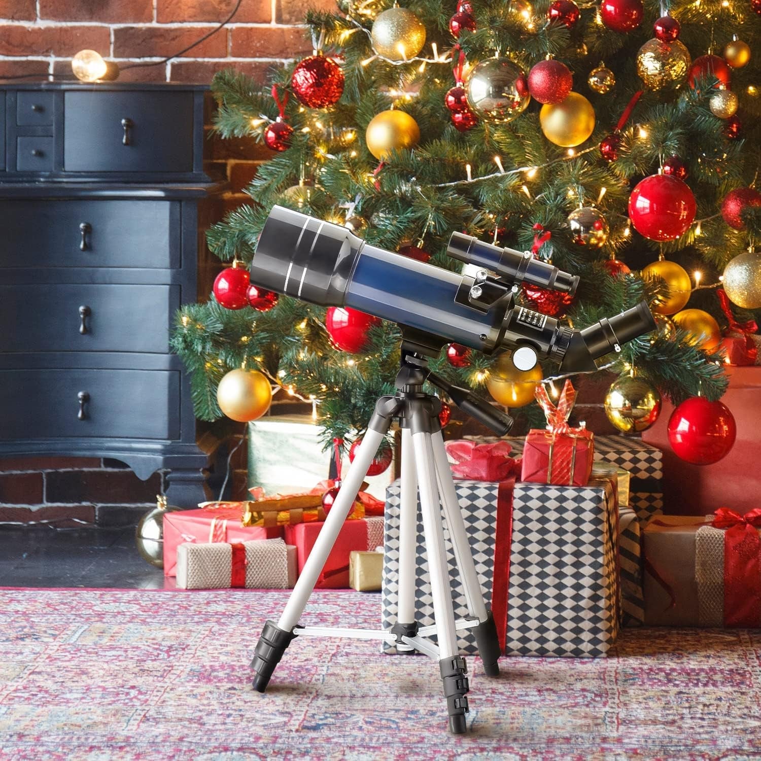 CelesView Telescope on a tripod in front of a decorated Christmas tree with presents underneath.