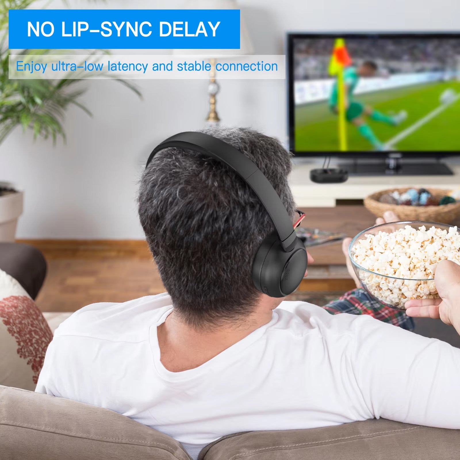 Person wearing Ekofonic 2.0 tv Headphones and eating popcorn while watching TV in a living room.