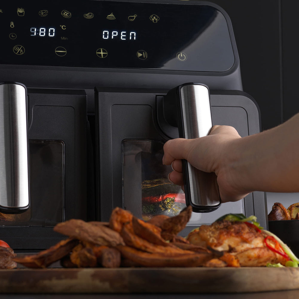 Person opening an Elarvo Air Fryer with food items on a wooden board in front