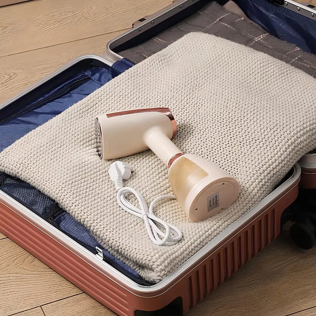 Ezorant Garment Steamer with cord on a blanket inside an open suitcase on a wooden floor.