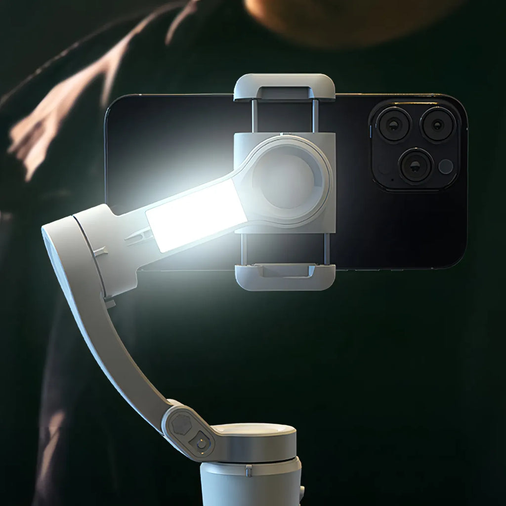 Smartphone with a mounted light and Kozenix Gimbal on a dark background