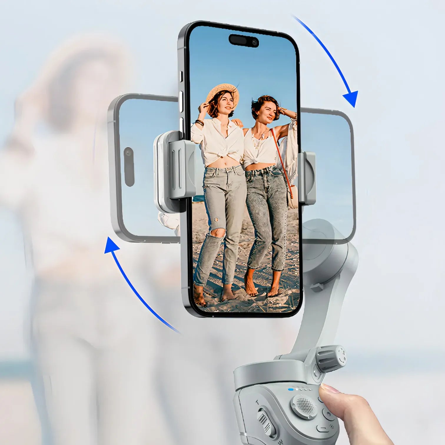 Hand holding a smartphone with a phone Kozenix Gimbal displaying two women on screen against a blurred background