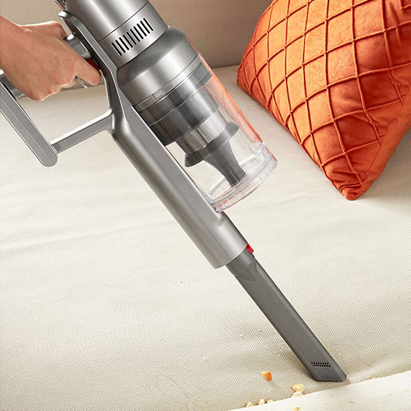 Ozitohome Hypersonics Pro Vacuum Cleaner cleaning a surface with an orange pillow in the background