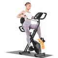 Woman exercising on a black Plianx Exercise Bike with an orange seat pad on a white background