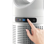 Hand pressing a button on an Purethcare 3 in 1 air purifier with a digital display.