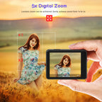Hand holding a RoamCami Action Camera with a digital zoom feature displayed, showing a woman in a field.