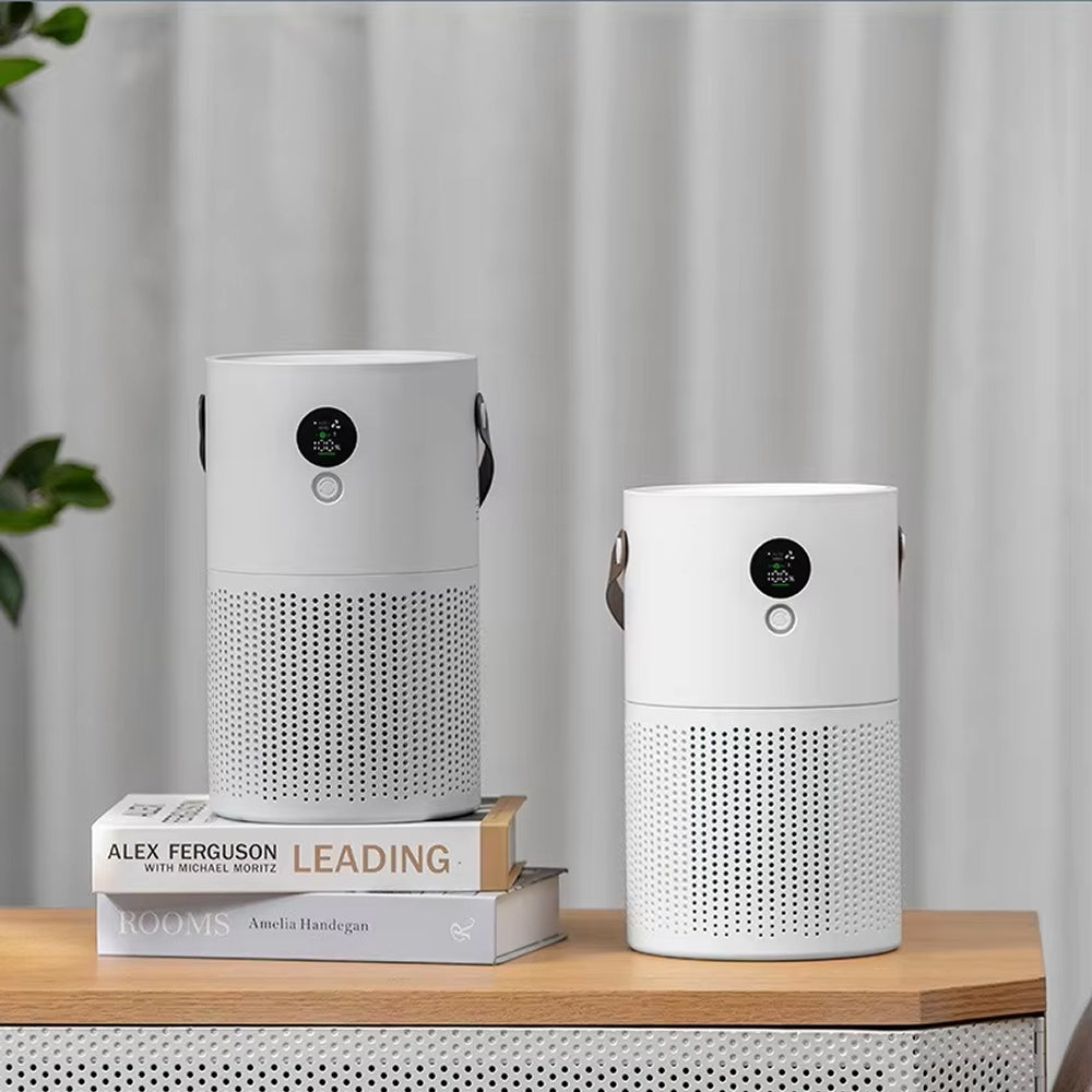 Two white cylindrical portable SkyPhis Air Purifier with black circular digital displays and hanging handles, shown on a wooden table with books in the background against a soft curtain backdrop.