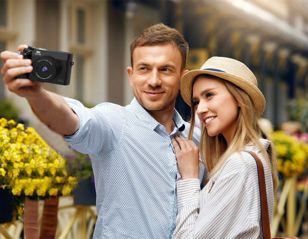 Man and woman taking a selfie outdoors with flowers and blurred background
