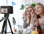 Two women applying makeup in front of a Smaven Roam D7 Digital Camera on a tripod, with a Wi-Fi symbol indicating remote control.