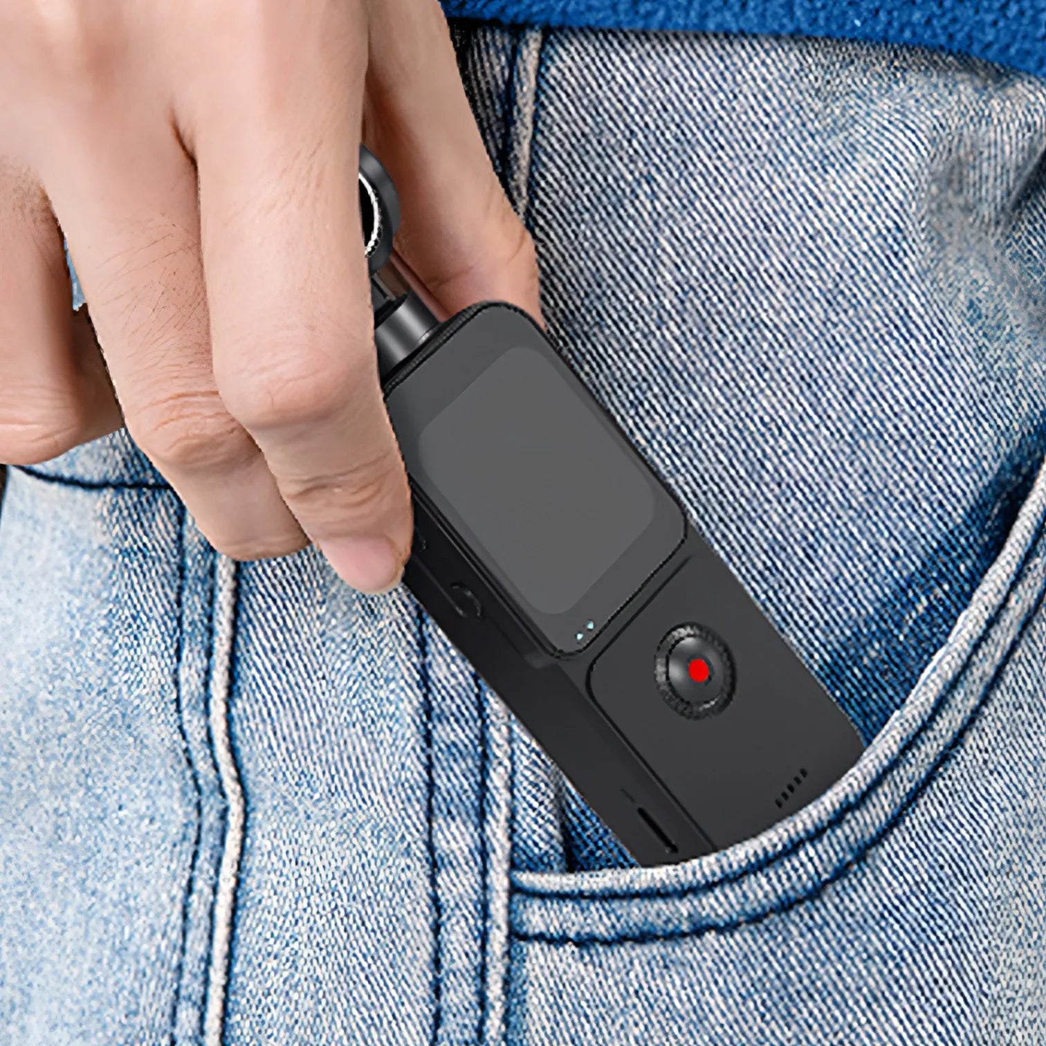 Hand placing a small Trovoro Pocket Camera into a blue denim pocket.
