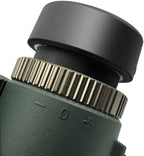 Close-up of a black and green Valisus Binoculars lens with a focus wheel on a white background