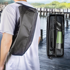 Person wearing a black crossbody bag with a green Vorthic Spotting Scope and black umbrella on a dock.