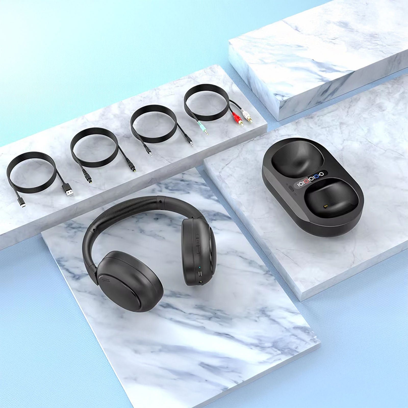 Black wireless Ekofonic 2.0 TV Headphones and charging case on a marble surface with a blue background