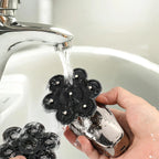 Hand washing a black and Trovoro Head Shaver under running water from a faucet.